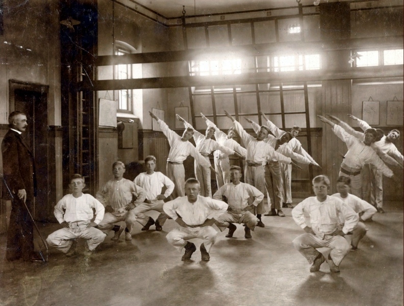 1916 Datidens gymnastiklæreres foretrukne disciplin, fritstående øvelser. Takten slås ved hjælp af en hockeystav.